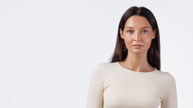 Bej rengi spor giyimli esmer bir kadının stüdyo portresi. Sağlık, cilt bakımı, aktif yaşam tarzı ve güzellik tanıtım materyalleri için mükemmel kaliteli bir görüntü..