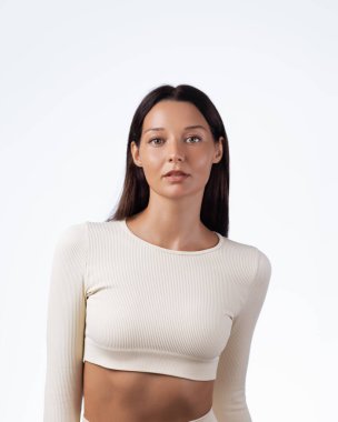 Bej renkli uzun kollu, parlak derili esmer kadın stüdyoda poz veriyor. Cilt bakımı, güzellik, sağlık, spor ve yaşam tarzı promosyon kullanımı için mükemmel kaliteli görüntü.