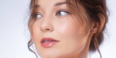 Beyaz tenli ve parlak dudaklı genç bir kadının yakın çekim stüdyosu. Kozmetik ve moda endüstrisinde cilt bakımı, makyaj ve güzellik ürünleri promosyonları için ideal..