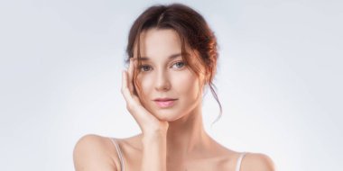 Bu samimi stüdyo resminde büyüleyici genç bir kadın büyüleyici bir cazibeyle bakarken parlak cildini ve doğal makyajını gözler önüne seriyor. Yumuşak ışıklandırma onun narin özelliklerini vurguluyor.