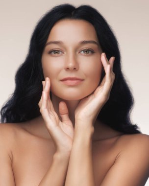 Stüdyoda poz veren beyaz tenli zarif bir kadının yakın çekimi. Kavramsal güzellik karesi cilt bakımı, spa tedavisi ya da kozmetik ürün reklamları için idealdir..