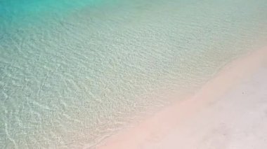 Sığ turkuaz deniz ve beyaz kumsal manzarası, yaz arkaplanları, seyahat reklamları, lüks tatil beldeleri, fotokopi alanı olan temiz tropikal dokular ve sakin okyanus havası için ideal..