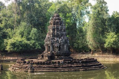 Tarihsel Neak Poan Tapınağı, Kamboçya 'nın Angkor Wat kompleksindeki yemyeşil ormanlarla çevrili kutsal bir göletin merkezinde yer alır. Seyahat, miras ve ruhsal konsept kullanımı için ideal.