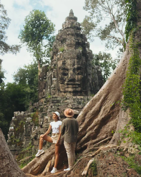 Genç çok kültürlü çift, Kamboçya 'nın Angkor Wat' ındaki görkemli Bayon Tapınağı 'na hayran. Seyahat, romantizm, kültürel keşifler ve orman maceraları için yüksek kaliteli görüntü konsepti.