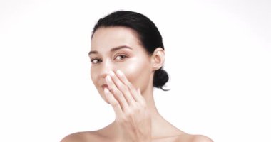 Güzel bir kadın burnuna krem sürerek yüzsüz bir gülümseme ekliyor, sonra da yanaklarına sürüyor. Otantik güzellik içeriği, kişisel bakım kampanyaları, kozmetik markalaşma ve sağlık videoları için ideal.