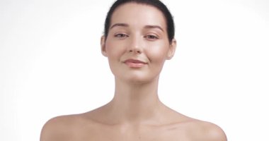 Beyaz bir kadın cilt ayininde yanaklarını nazikçe okşuyor. Yüz tazeleme, güzellik tedavileri ve lüks nemlendirici kozmetik promosyonları için kavramsal görüntüler.