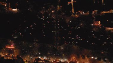 Hoi An nehrinin hareketli fener tekneleri ve parlayan şehir ışıklarıyla hava gece görüşü. Seyahat, turizm, Asya kültürü, festival görselleri ve yüksek kaliteli insansız hava aracı görüntüleri için ideal.