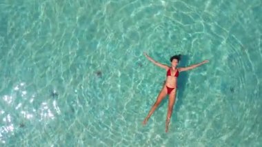 Starfish Beach Phu Quoc 'ta turkuaz denizde yüzen kadın görüntüsü, yaz seyahati, rahatlama ve özgürlük temaları için ideal, turizm reklamları, refah içeriği ve lüks tatil videoları için iyi.