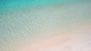 Berrak turkuaz su, özgürlük konsepti, yaz tatili ve minimalizm ile tropikal kumsalda tek başına yürüyen beyaz bir kadın. Seyahat, sağlık, yaşam tarzı veya lüks tatil beldesi için yüksek kaliteli imaj