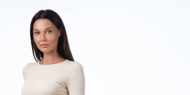 Tarafsız spor giysilerinde, stüdyo ortamında beyaz arka planda poz veren minimum vücut fitness modeli. Geniş kopya alanı olan modern temiz görünüş, aktif giyim markaları, çevrimiçi dükkanlar, posterler ve web için mükemmel.