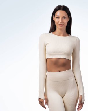 Stüdyoda şık bej formalı, sırıtan esmer kadın poz veriyor. Sağlık, moda tanıtımı, yaşam tarzı ve sağlıkla ilgili reklamlar veya bloglar için yüksek kaliteli imaj ideal.