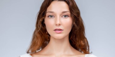 Işıl ışıl cildi ve sakin ifadesi olan, beyaz dantelli, cilt bakımı için ideal, temiz güzellik, moda ve sağIıklı yaşam tarzı reklamı olan bir kadının minimal güzelliği..