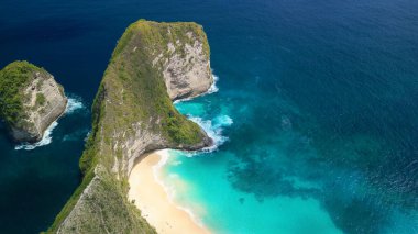 Mavi bir göl ve el değmemiş kum üzerinde dramatik uçurumları olan Kelingking Beach Bali 'nin yüksek kaliteli insansız hava aracı videosu, seyahat reklamları, macera temaları, turizm görselleri ve hedef pazarlama varlıkları için ideal.