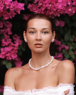 İnci kolyeli zarif kadın portresi ve pembe bougainvillea arkaplan, güzellik reklamları için ideal, gelin makaleleri, lüks cilt bakımı, romantik temalar, ve bahar modası, yüksek kalite.