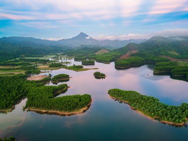 Tra Ly Gölü 'nün insansız hava aracı görüntüsü, Tayland Binh, Vietnam yemyeşil adalar, sakin sular, uzak dağlar ve sabah bulanıklığı. Seyahat reklamları, web afişleri, başyazılar ve baskılar için ideal.