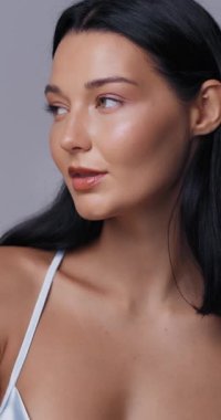 Kendine güvenen bir mankenin, kalın yakalı, ipeksi beyaz elbiseyle poz verdiği yakın çekim. Göz alıcı makyaj ve zarif bir stil. Güzellik, moda kampanyaları, lüks reklamlar için ideal..