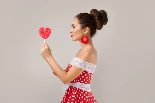 Happy Woman Holding red Lollipop Shape of Heart. Pin-up retro style. — Stock Photo, Image