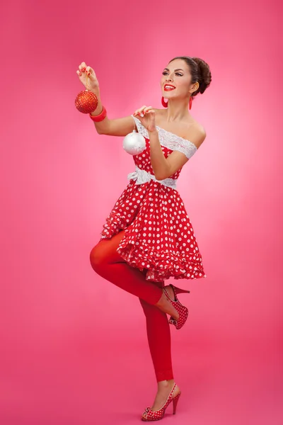 Gyönyörű nő tartja karácsonyi játékok. Pin-up Retro stílusú. — Stock Fotó