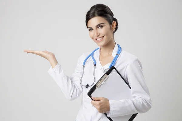 Leende läkare kvinna med stetoskop. Presentera något — Stockfoto
