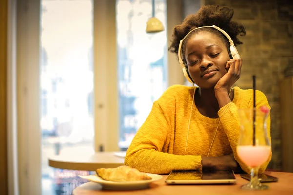 Femme écoutant de la musique dans un café — Photo