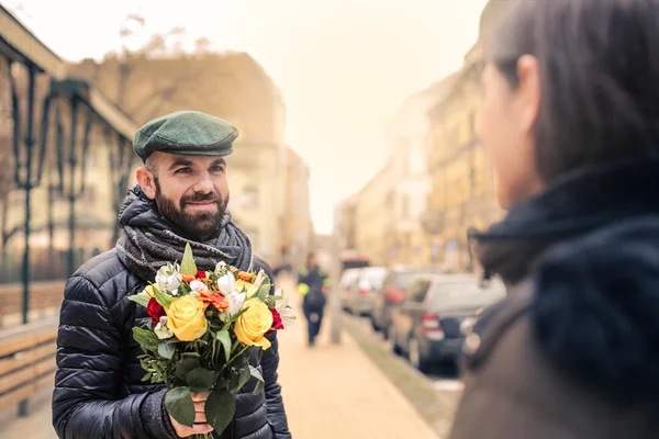 Man geeft bloemen aan vrouw — Stockfoto