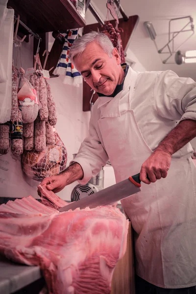 Carniceiro a cortar carne — Fotografia de Stock