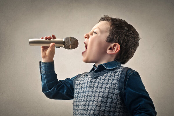 Ребенок поет с микрофоном
