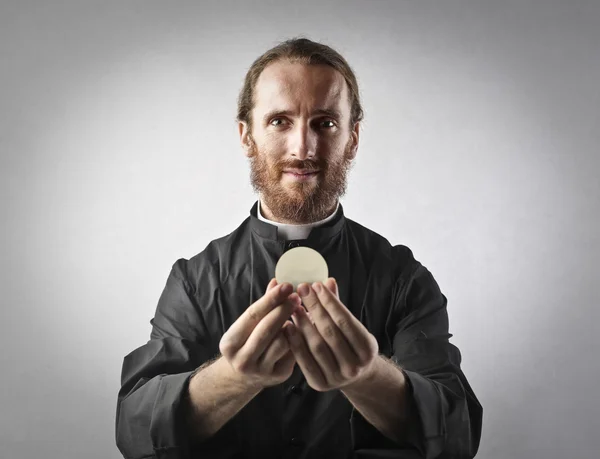 Priester mit heiliger Hostie — Stockfoto