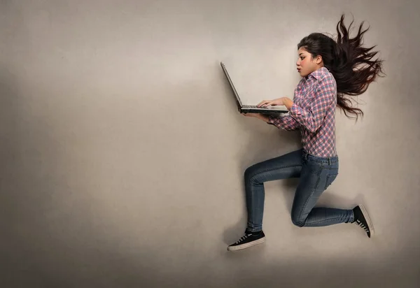 Menina correndo com computador — Fotografia de Stock