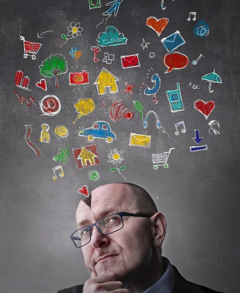 Empresário pensando com ícones sobre sua cabeça — Fotografia de Stock