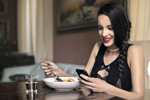 Kobieta jedzenie i SMS-y — Zdjęcie stockowe