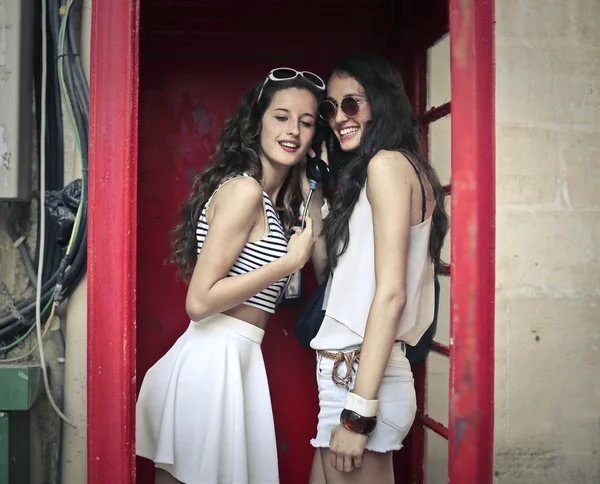 Two friends in an old phone box — Stock Photo, Image