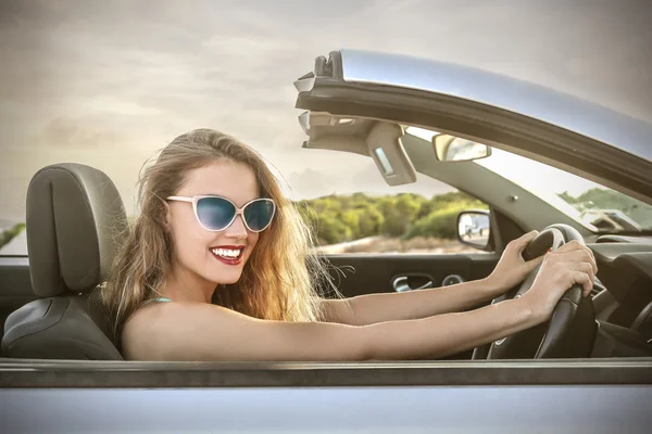 Prachtige blond meisje besturen van een auto — Stockfoto