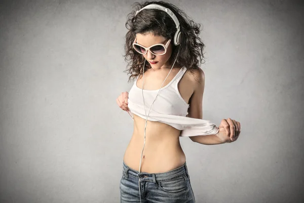 Adolescente con un top blanco y auriculares y gafas de sol — Foto de Stock