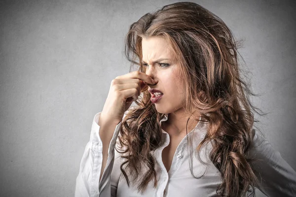 Geschäftsfrau sieht angewidert aus und hält ihre Nase — Stockfoto