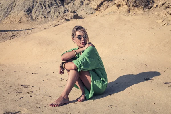 Mulher elegante vestindo um vestido verde sentado ao sol — Fotografia de Stock