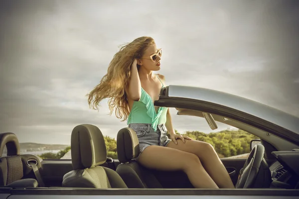 Menina bonita sentada em um carro — Fotografia de Stock