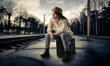 bavul üzerinde oturan