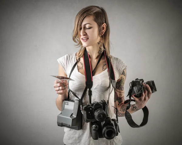 Mladá žena s mnoha fotoaparáty — Stock fotografie