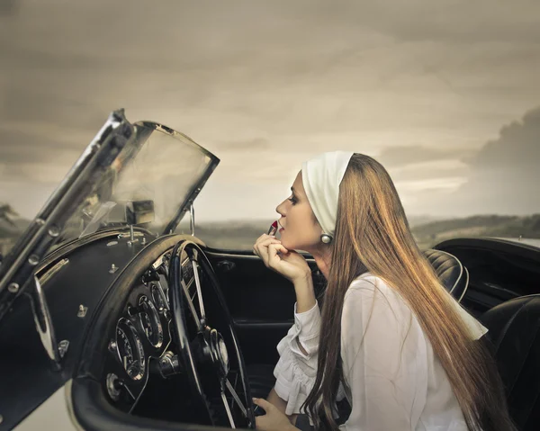 Woman in classic car — Stockfoto