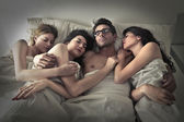 Mann schläft mit drei Frauen