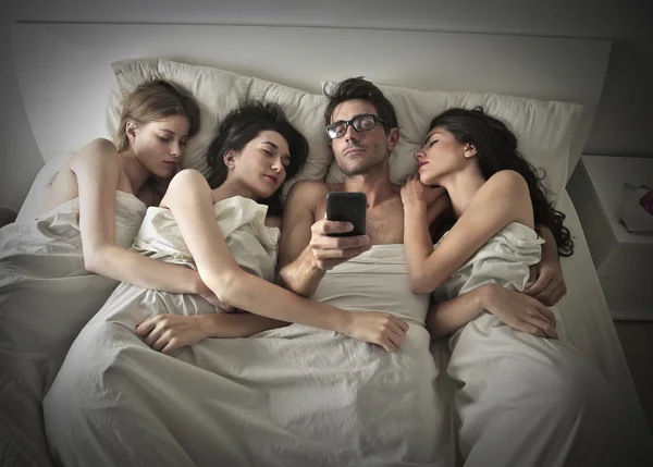 睡在一起三个女人的男人 — 图库照片