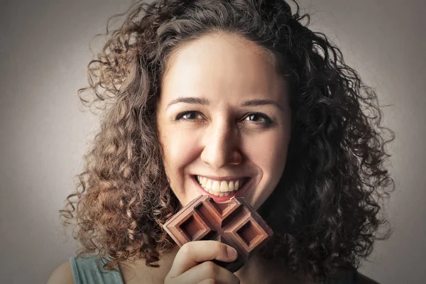Счастливая девушка ест шоколад — стоковое фото