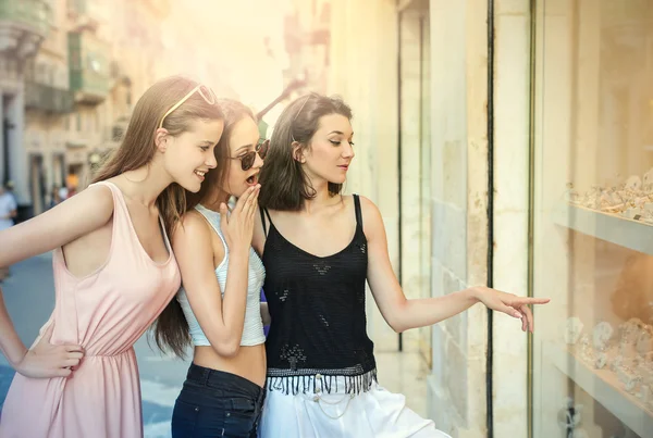 Tre amici che guardano la finestra di un negozio — Foto Stock