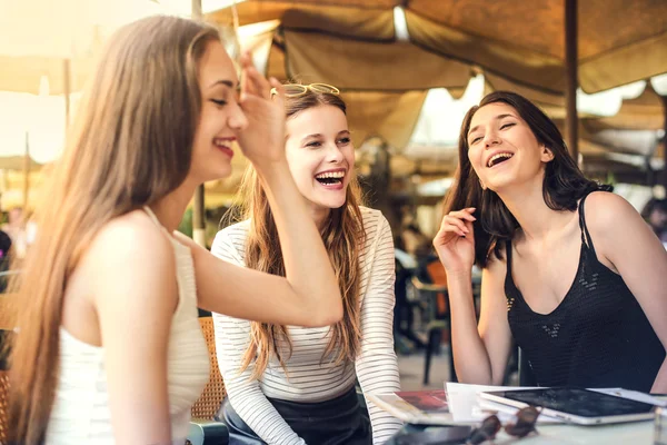 Drei Freunde sitzen lachend in einem Café — Stockfoto