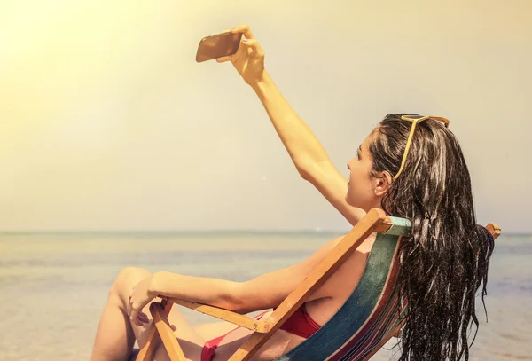 Belle femme à la plage faisant un selfie — Photo