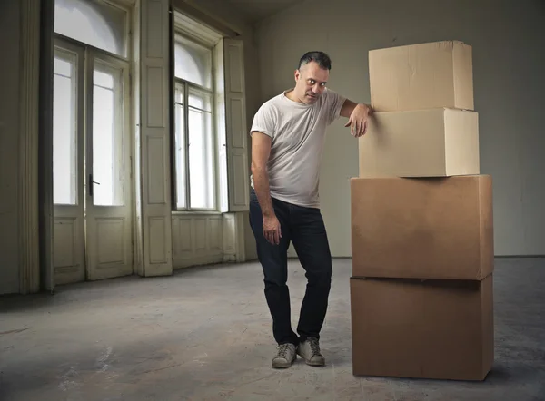 Чоловік стоїть поруч з купою коробок — стокове фото