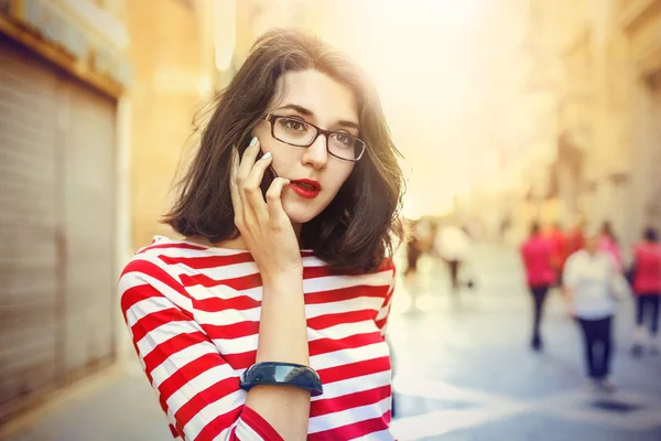 Mladá žena nosí červenou rtěnku dělá telefonní hovor — Stock fotografie