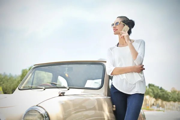 Menina fazendo um telefonema enquanto estava ao lado de um carro — Fotografia de Stock