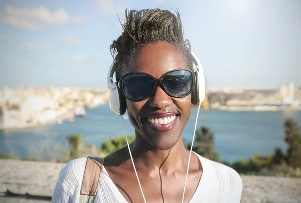 Femme souriante écoutant de la musique — Photo